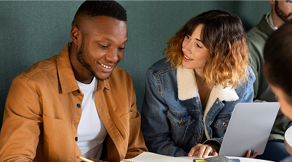 Two colleagues discussing data on a laptop